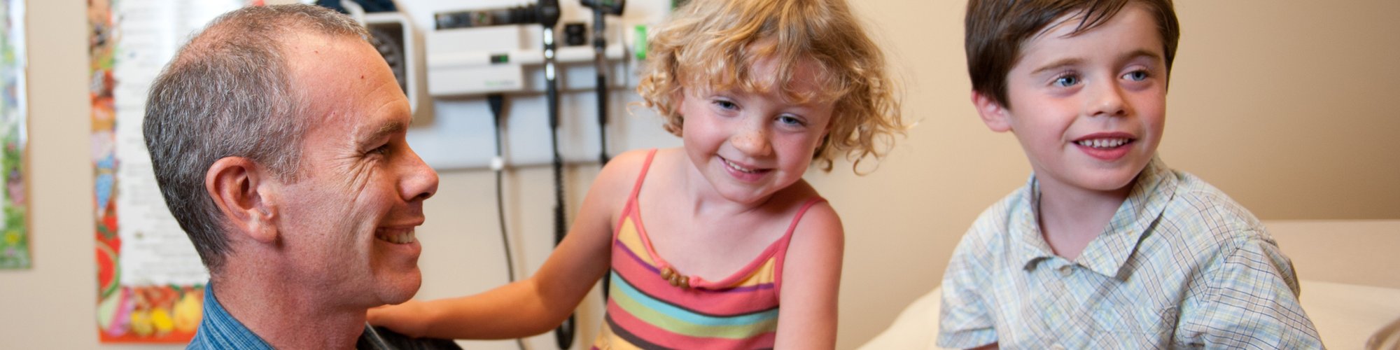 Dr. Butruille talks with two pediatric patients at the Family Practice Clinic.