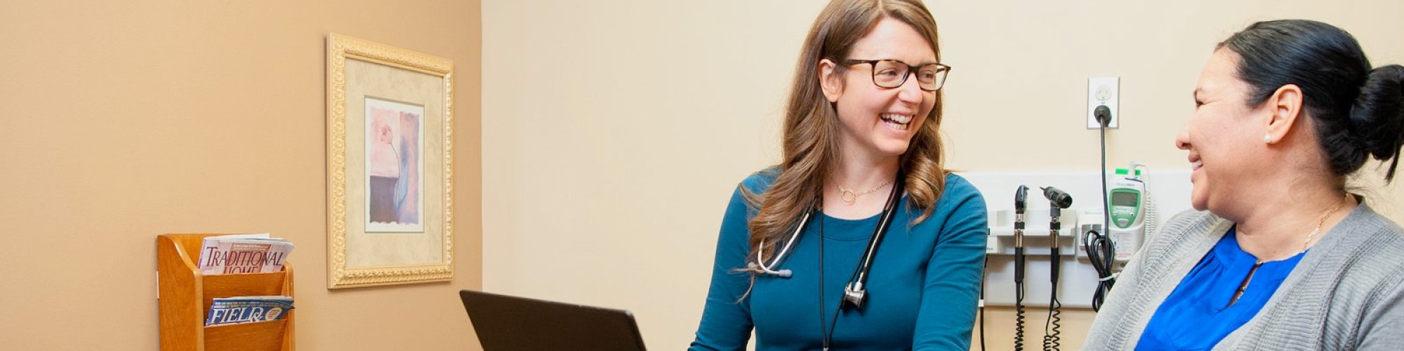 Two Cascade Medical employees talking with each other in a room.