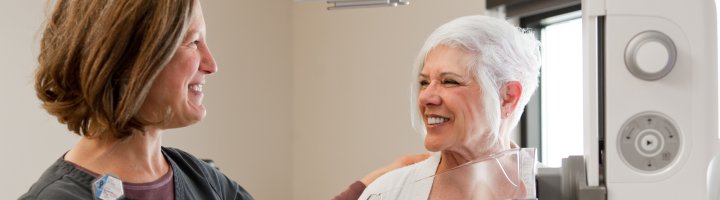 Mammographer Holly Blue and a patient next to the new 3D mammography unit.
